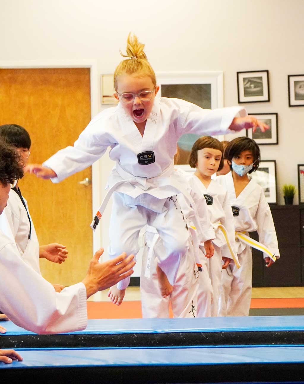 a tiny warrior is doing warming up in the martial arts class